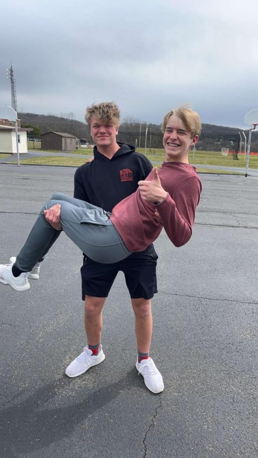 Junior Will Nagy and sophomore Louis Flowers show their adoration for each other as teammates  despite the dreary weather.  The tennis team has a packed schedule during season. 