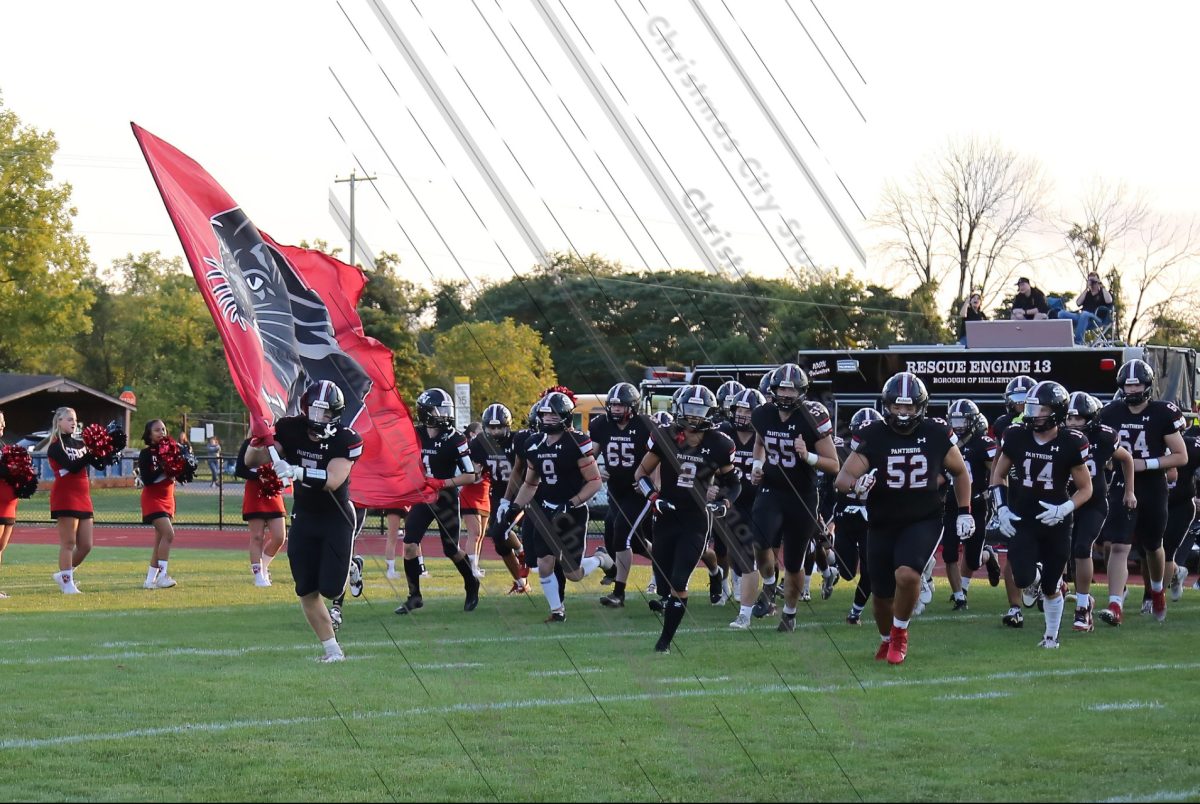 Saucon Valley Varsity football team running out led by senior Andrew Gilbert holding the flag. The run out can be a very exciting moment for the football players getting ready for their game.