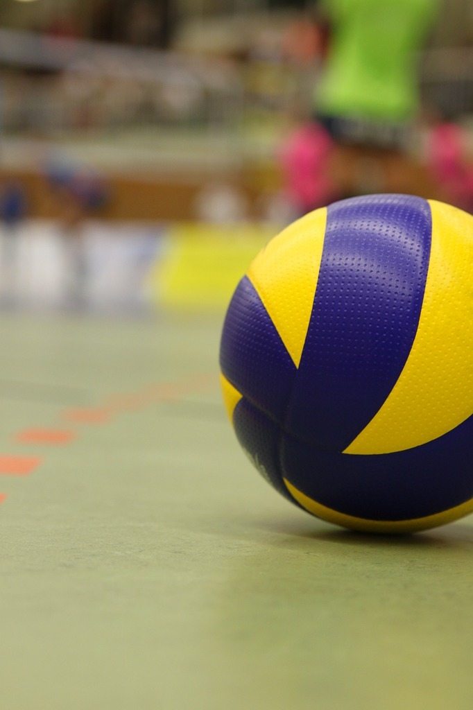 The image shows a volleyball on a court. Volleyballs are smaller, softer versions of basketballs.