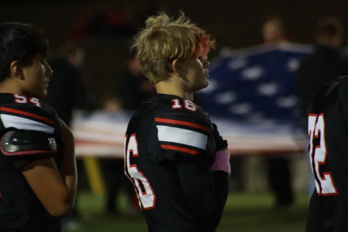 Sophomore PJ Miller standing for the flag during the national anthem. 