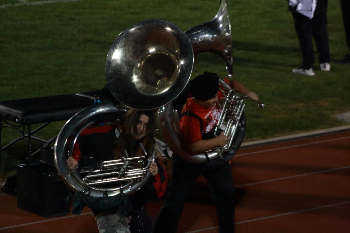 Two Alumni marching band players preforming during halftime.