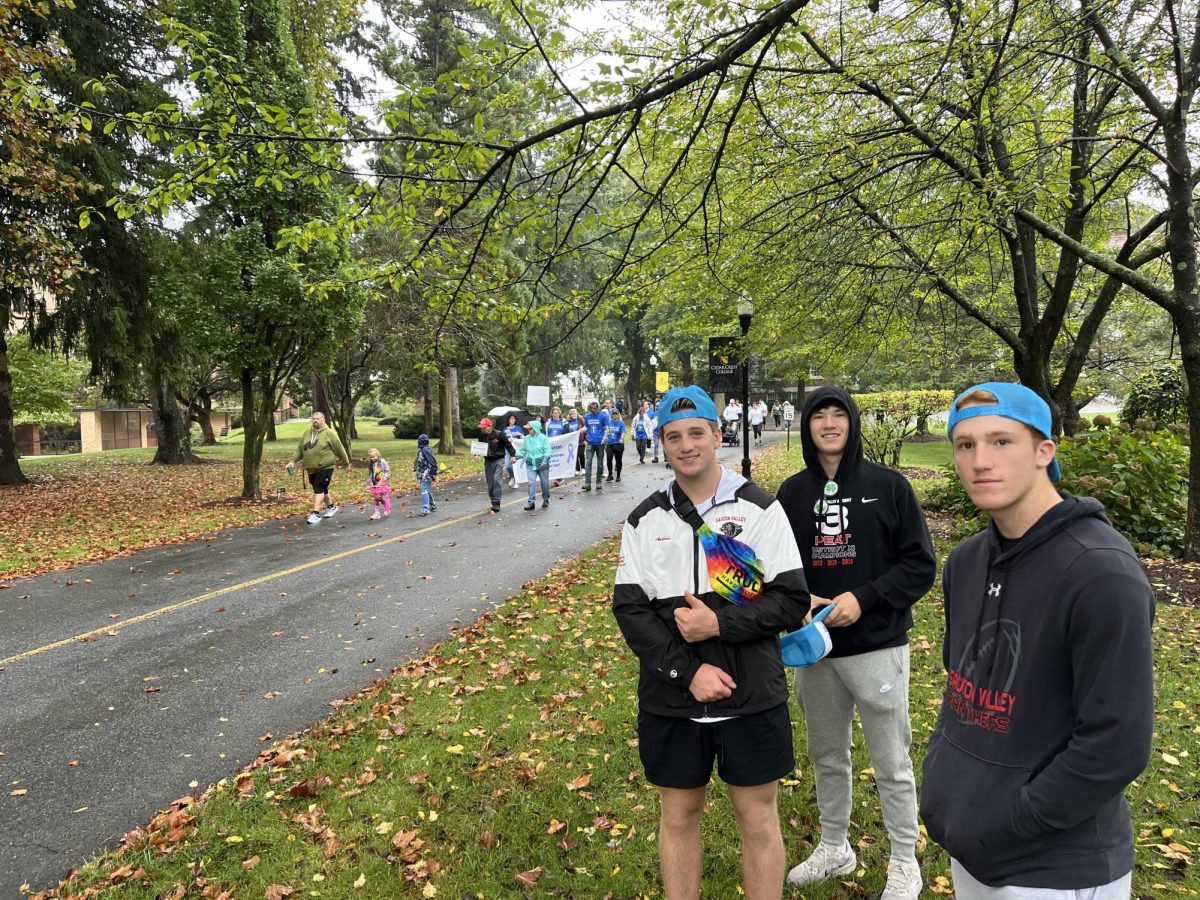 Andrew Gilbert, Zackary Male, and Jack Robertson posing in front of the walk. The students cheered as people walked for ALS.