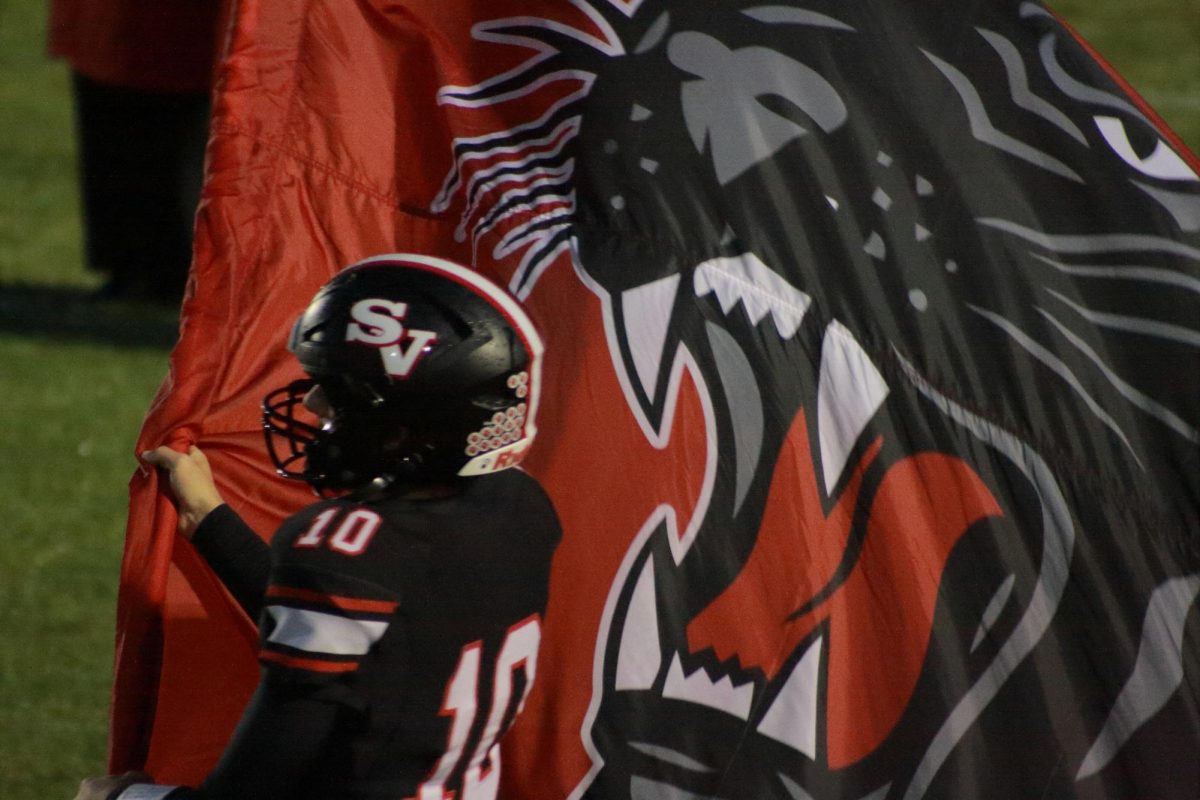 Senior Peter Albano carrying the flag at Friday’s home game against Catasauqua. Saucon went 62-14 this game making our school 5-1 this season. 