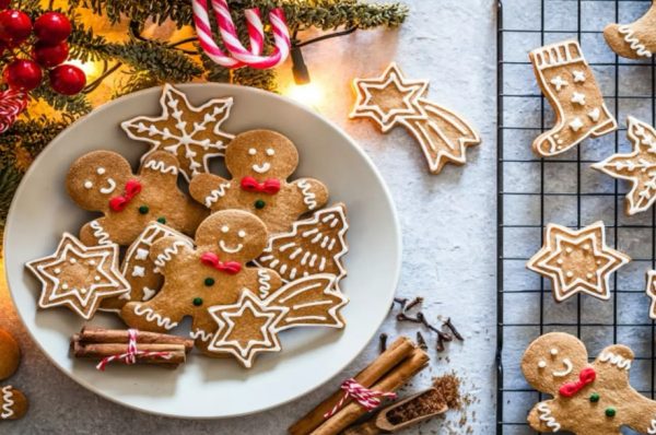 This is a tray and bowl full of Christmas cookies with various decorations. This could be a setup for some people’s tables with their treats.