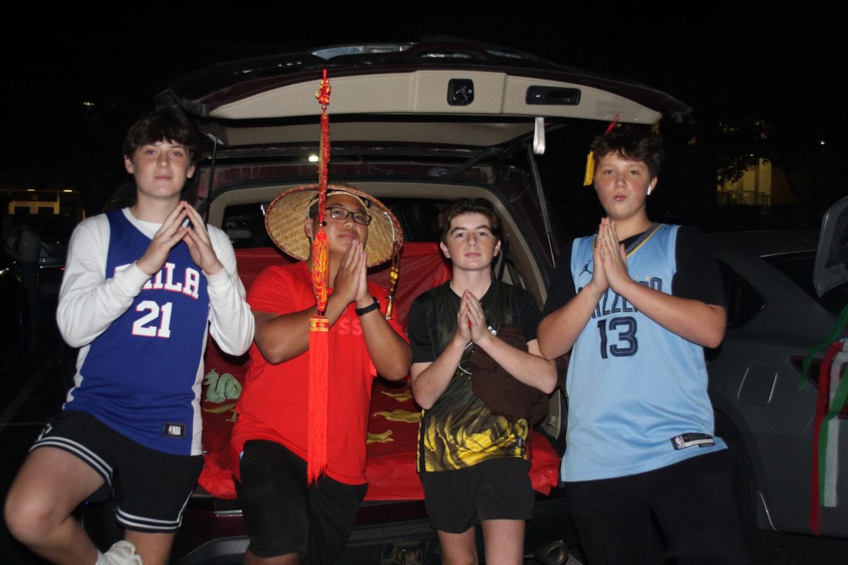 Freshmen Andrew Young, Anthony Albano and Parker Duh pose with Senior Jerry Lin in front of his themed Trunk. 