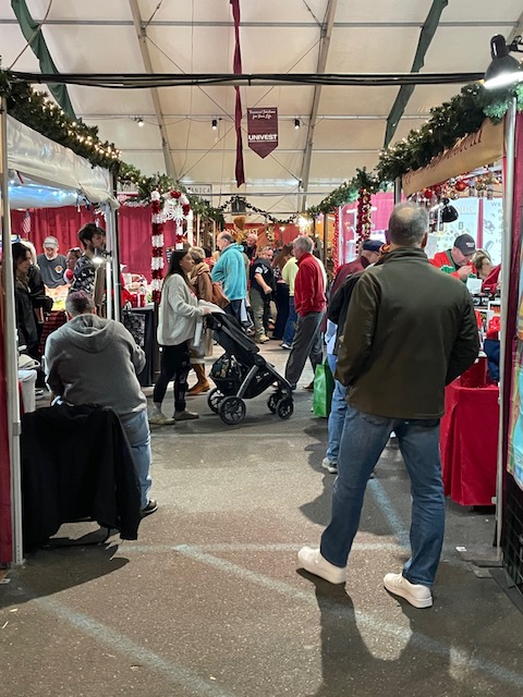 Indoor shot of the christkindlmarket tent, filled with people.