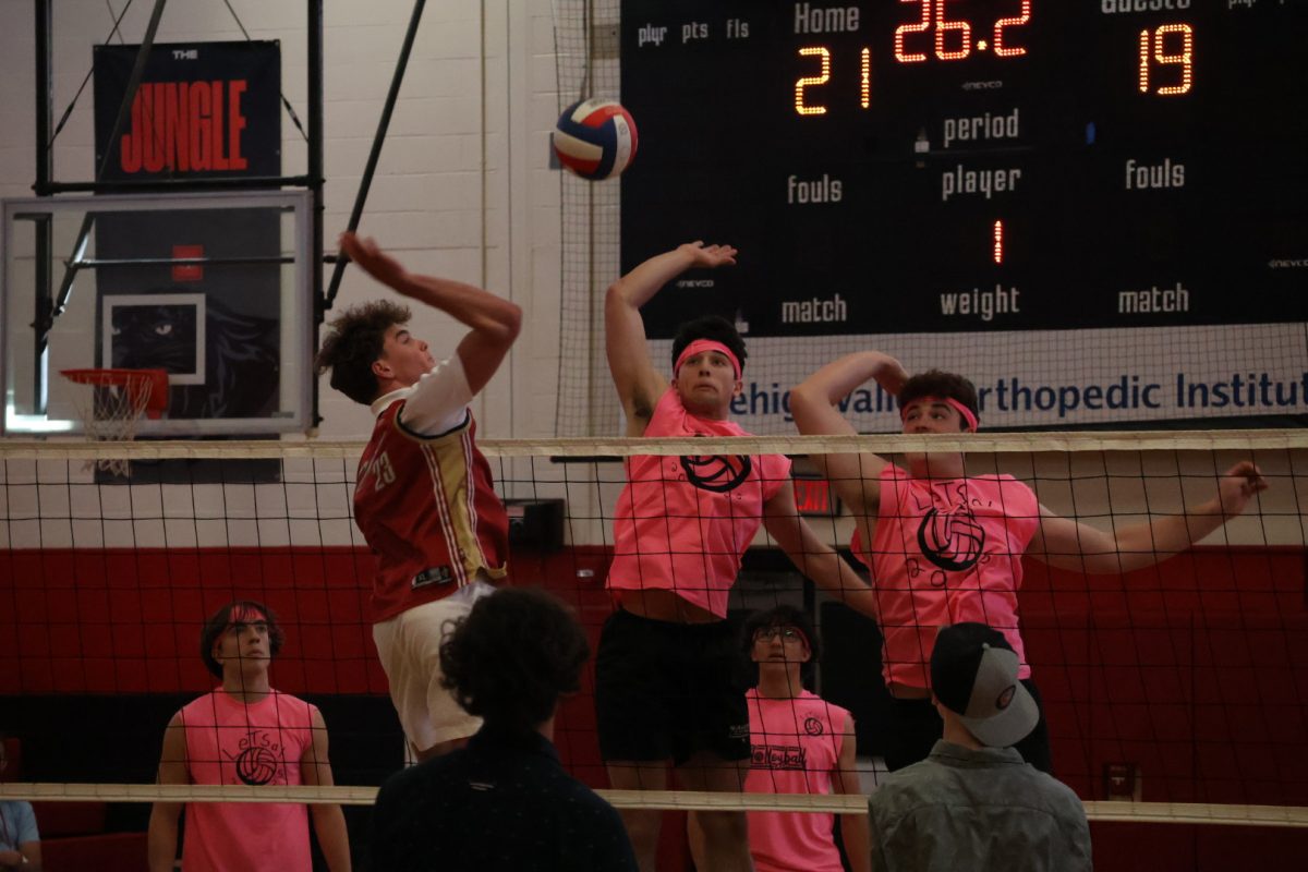 Group of three players going for the spike. 