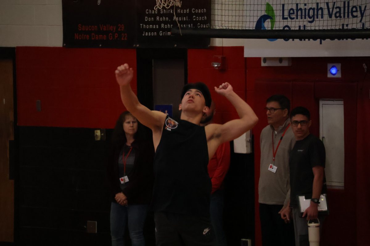 Senior Cole Hubert goes for the serve.