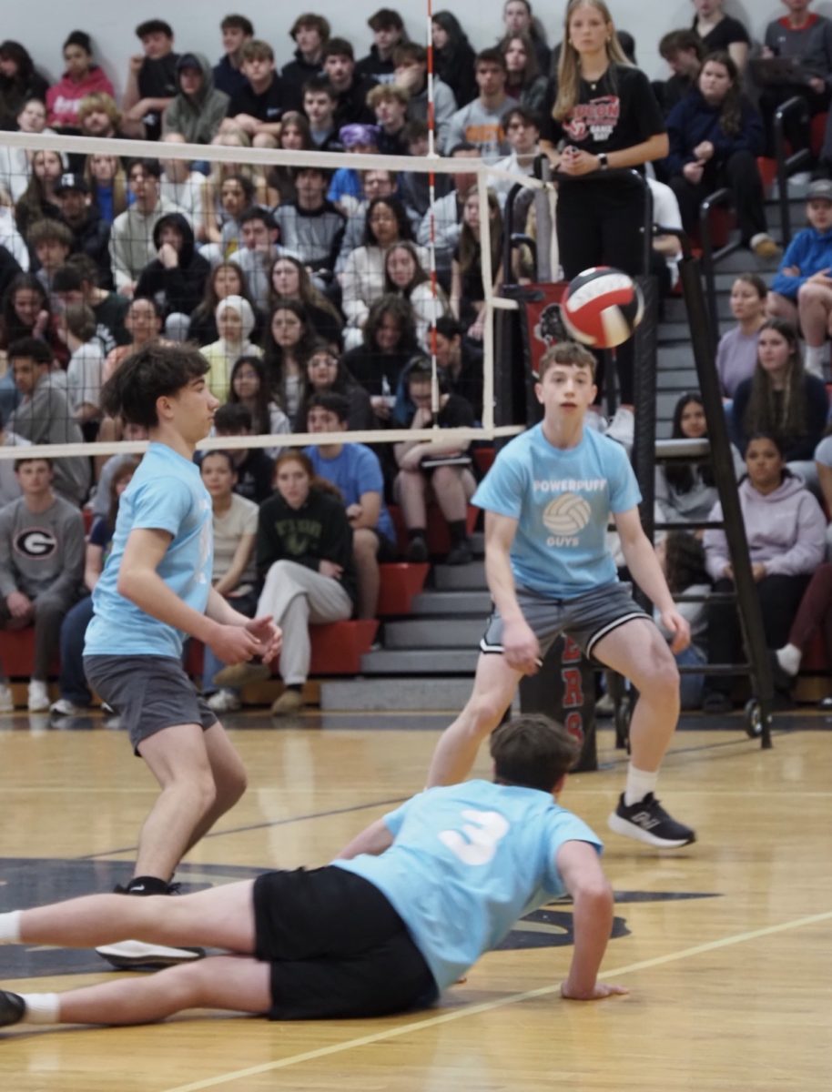Students in the middle of a volleyball game.
