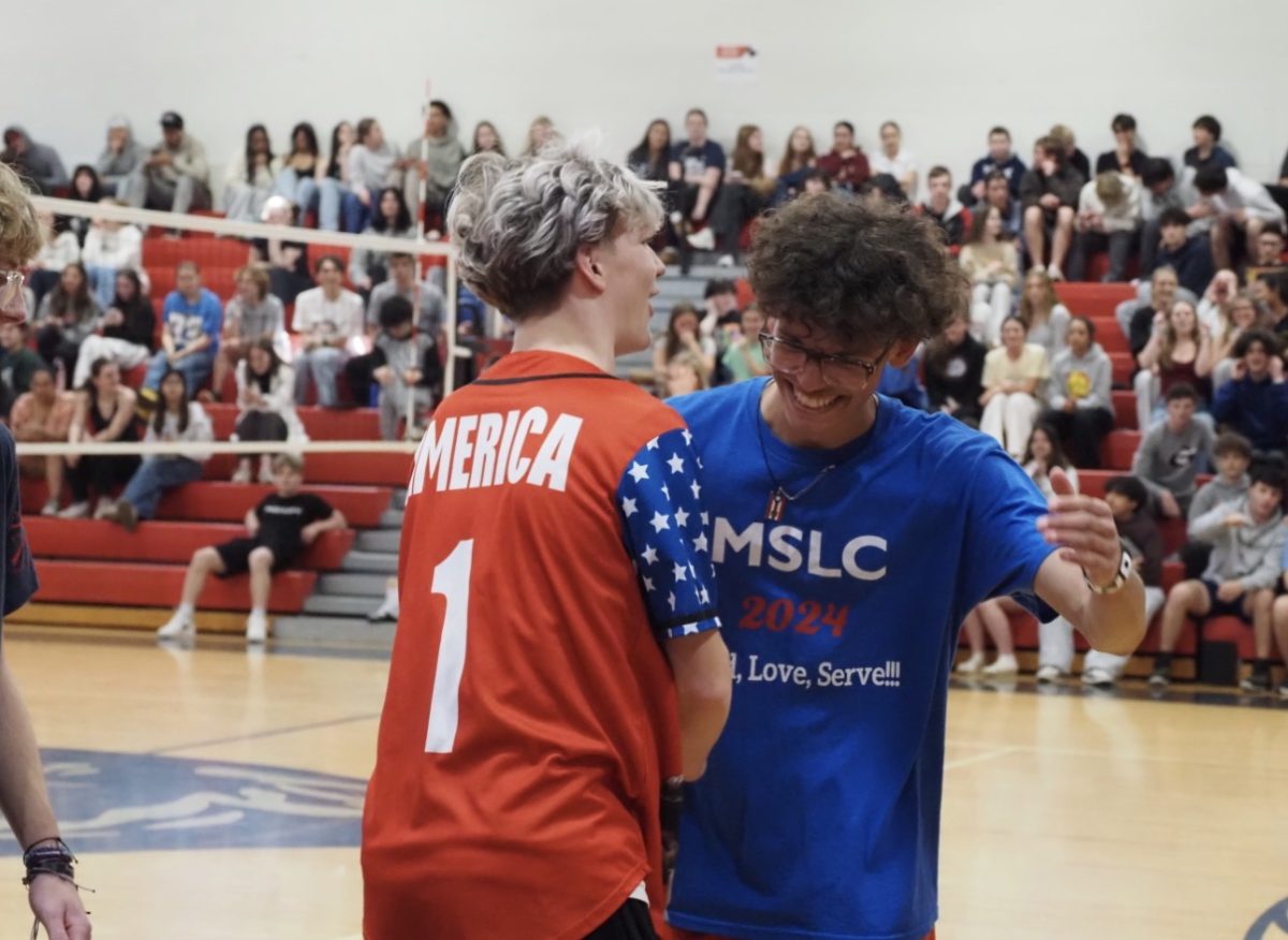 Two team members celebrating a volleyball win.