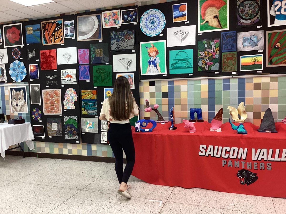 Student admiring the high school art show.