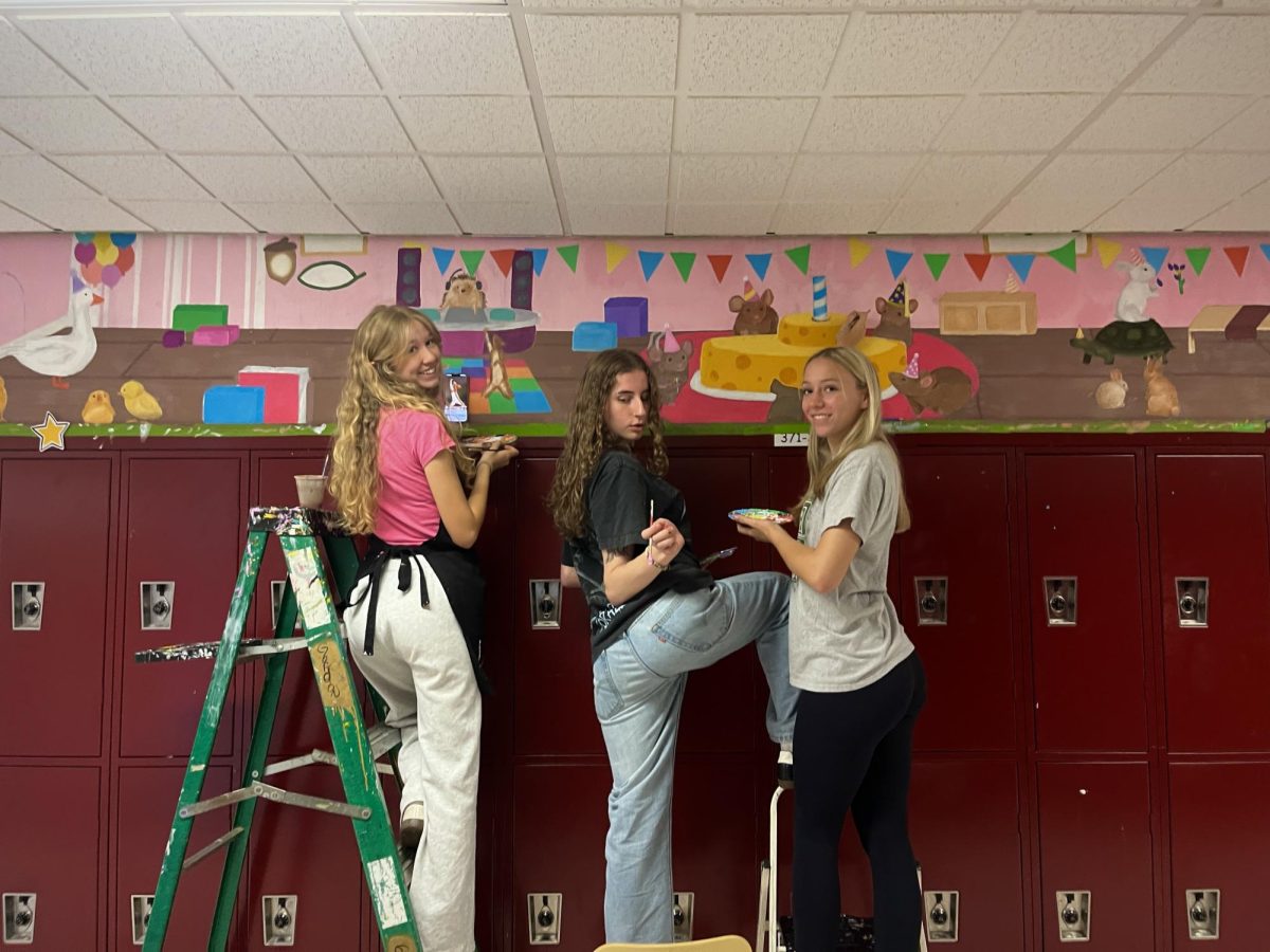 Violet Whitley, Meghan James, and Emma Fenstermacher working hard on their mural.